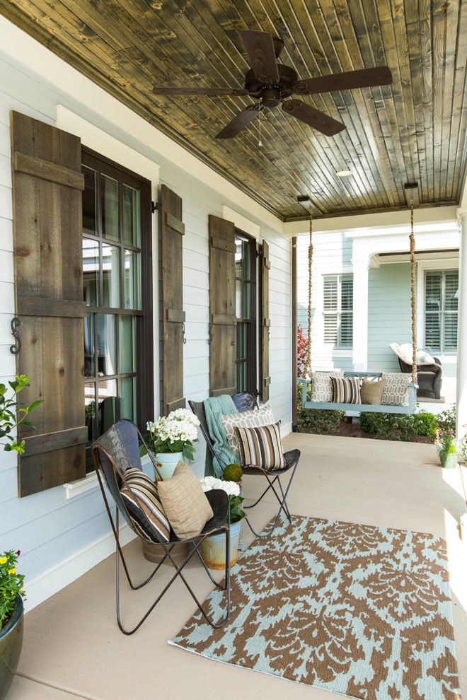 Photo of an eclectic front yard verandah in Louisville with concrete slab.
