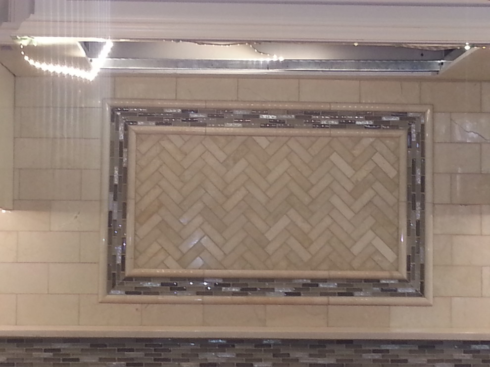 Example of a mid-sized l-shaped light wood floor eat-in kitchen design in Newark with a drop-in sink, raised-panel cabinets, white cabinets, granite countertops, white backsplash, subway tile backsplash, stainless steel appliances and an island