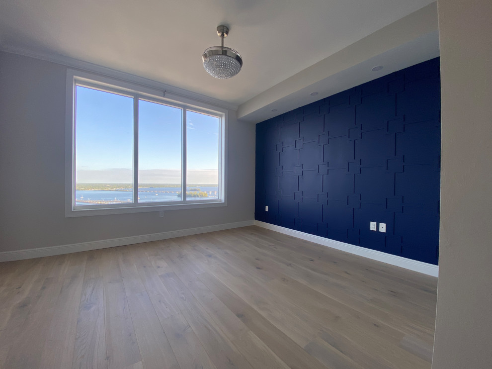 Cette image montre une chambre parentale design de taille moyenne avec un mur bleu, parquet clair et un sol multicolore.