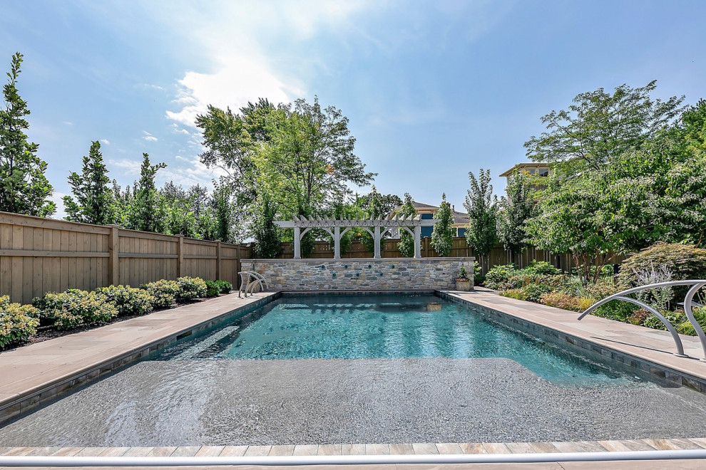Example of a large transitional backyard stone, wood fence and rectangular full sun pool landscaping design for summer in Chicago