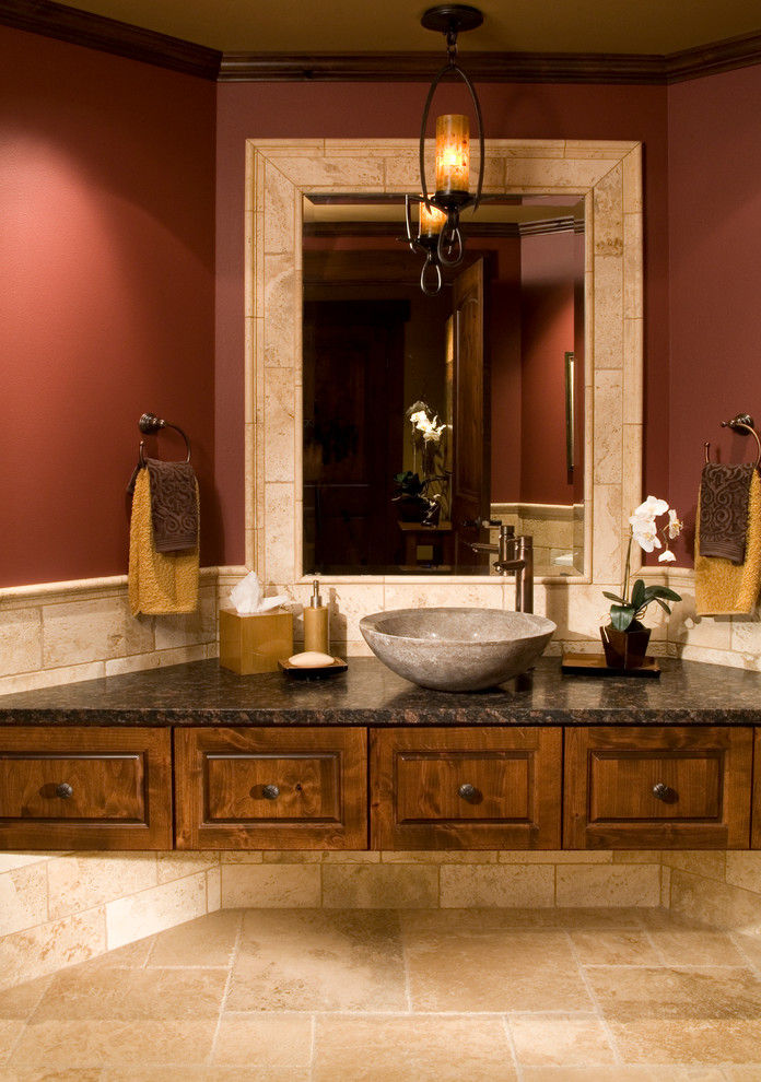 Inspiration for a mid-sized transitional powder room in Denver with a vessel sink, recessed-panel cabinets, medium wood cabinets, marble benchtops, beige tile, ceramic tile, red walls and ceramic floors.