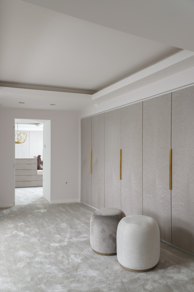 Design ideas for a large contemporary women's dressing room in Manchester with flat-panel cabinets, grey cabinets, carpet, grey floor and coffered.