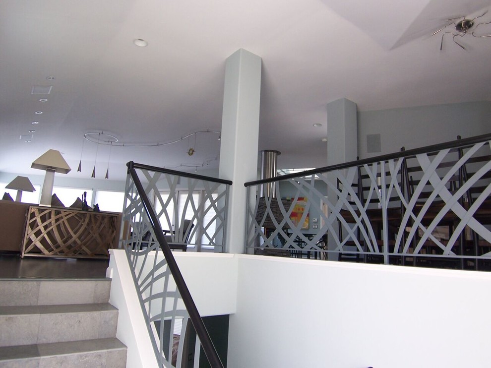 Photo of a mid-sized modern tile staircase in San Luis Obispo with tile risers and metal railing.