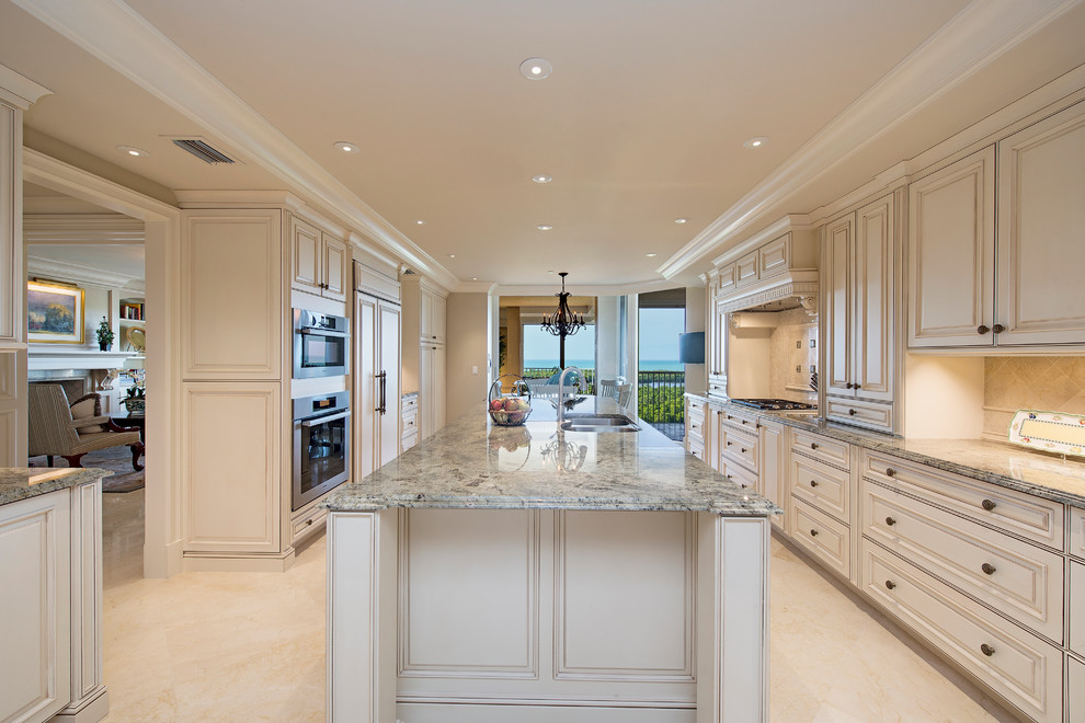 Design ideas for a large traditional galley eat-in kitchen in Miami with an undermount sink, granite benchtops, beige splashback, stainless steel appliances and with island.