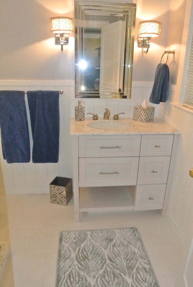 Inspiration for a mid-sized transitional master white tile and ceramic tile porcelain tile corner shower remodel with an undermount sink, recessed-panel cabinets, white cabinets, marble countertops, a one-piece toilet and gray walls