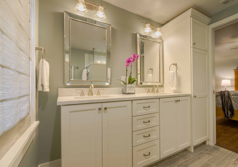 Photo of a mid-sized country master bathroom in Chicago with shaker cabinets, white cabinets, an alcove shower, a two-piece toilet, white tile, marble, grey walls, ceramic floors, an undermount sink, solid surface benchtops, grey floor, a hinged shower door, a double vanity, white benchtops, a freestanding vanity, wallpaper and decorative wall panelling.