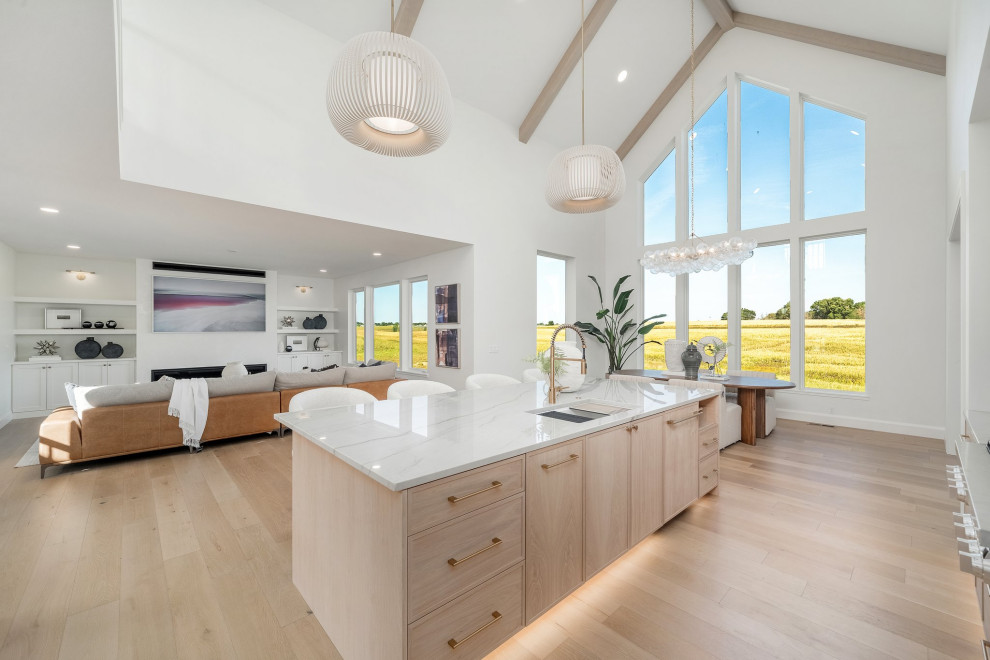 Example of a mid-sized transitional l-shaped light wood floor, beige floor and vaulted ceiling eat-in kitchen design with an undermount sink, recessed-panel cabinets, light wood cabinets, quartzite countertops, white backsplash, quartz backsplash, stainless steel appliances, an island and white countertops