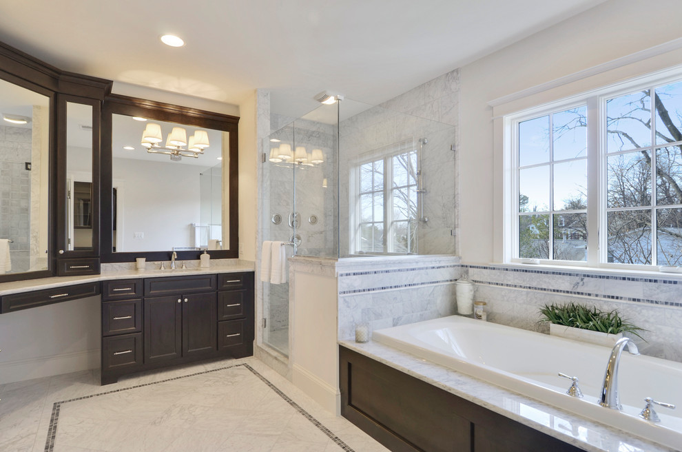 Photo of a large transitional master bathroom in DC Metro with recessed-panel cabinets, dark wood cabinets, a drop-in tub, a double shower, a two-piece toilet, multi-coloured tile, marble, white walls, marble floors, an integrated sink and marble benchtops.