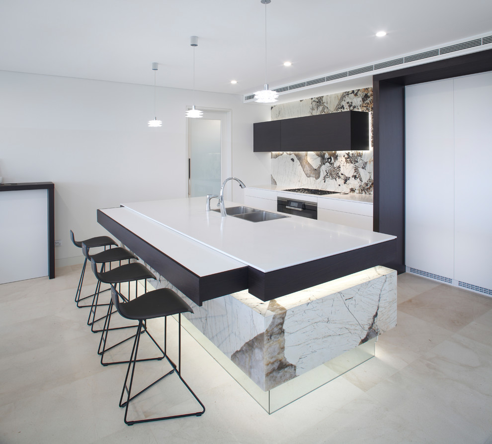 This is an example of a contemporary galley kitchen in Melbourne with with island, a double-bowl sink, flat-panel cabinets, black cabinets, white splashback, beige floor and white benchtop.