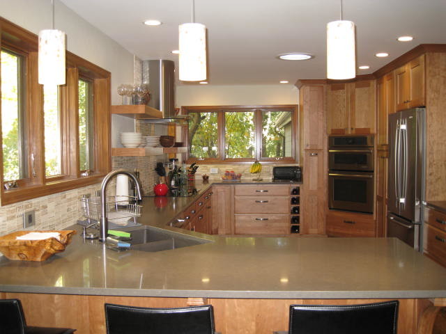 Example of a kitchen design in Denver with a double-bowl sink, recessed-panel cabinets, medium tone wood cabinets, beige backsplash and stainless steel appliances