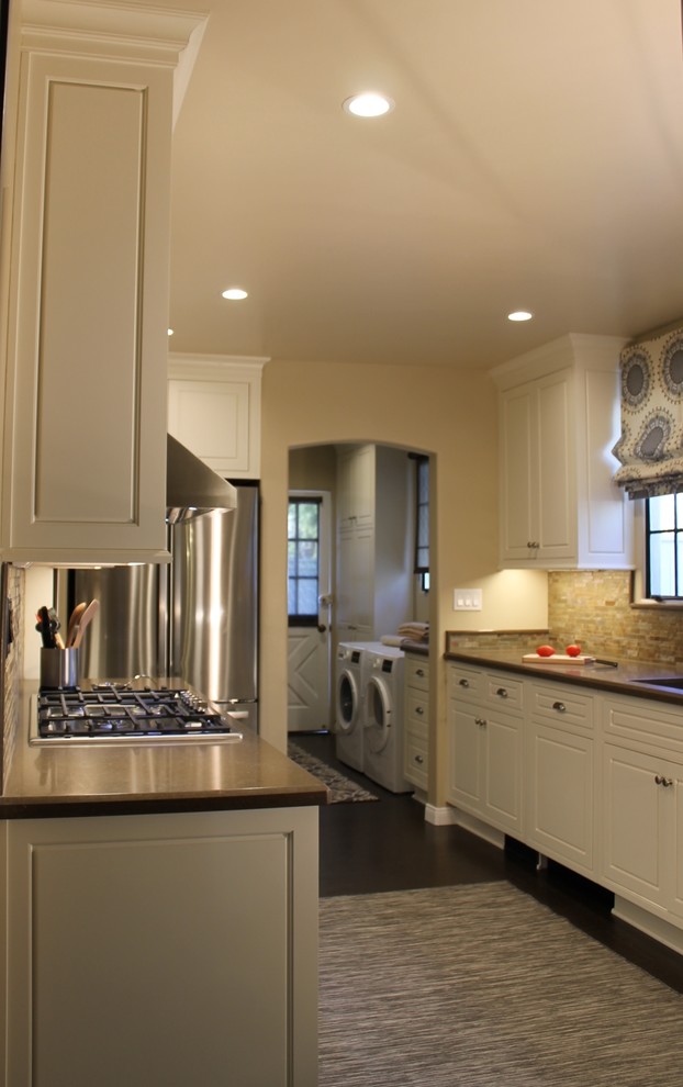 Photo of a large transitional galley separate kitchen in Los Angeles with a double-bowl sink, beaded inset cabinets, white cabinets, quartz benchtops, beige splashback, slate splashback, stainless steel appliances, cork floors, no island and brown floor.