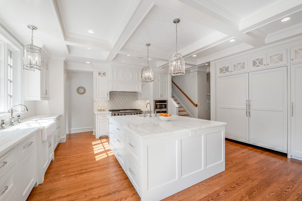 Design ideas for a large traditional l-shaped eat-in kitchen in New York with a farmhouse sink, beaded inset cabinets, white cabinets, marble benchtops, white splashback, ceramic splashback, panelled appliances, light hardwood floors and with island.