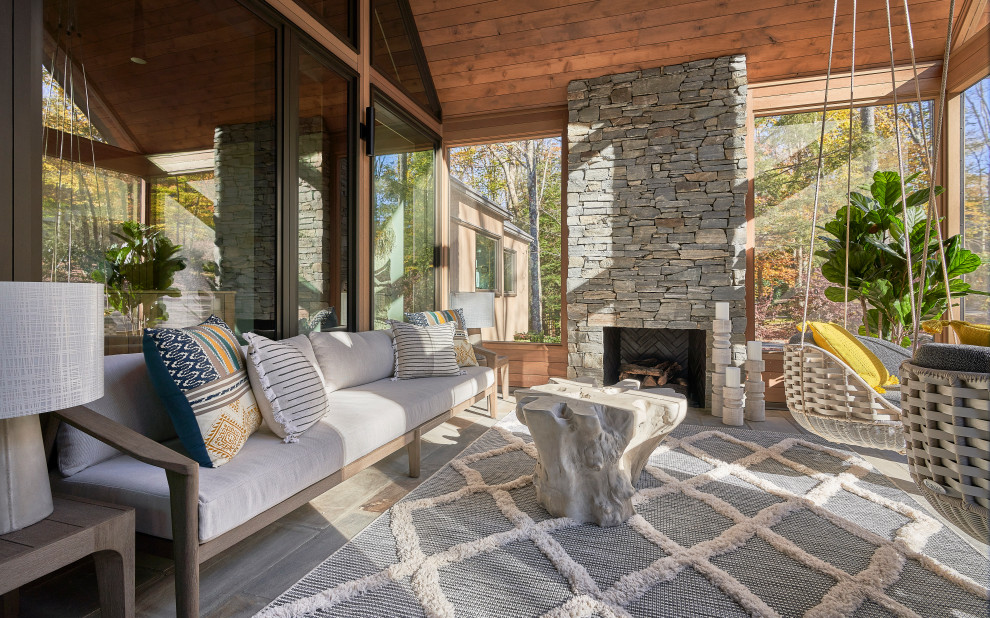 Inspiration for a large rustic stone front porch remodel in Other with a fireplace and a roof extension