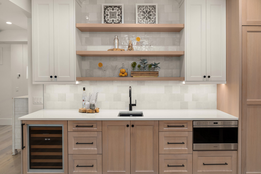 Country medium tone wood floor home bar photo in Seattle with an undermount sink, floating shelves, white cabinets, quartz countertops, white backsplash, porcelain backsplash and white countertops