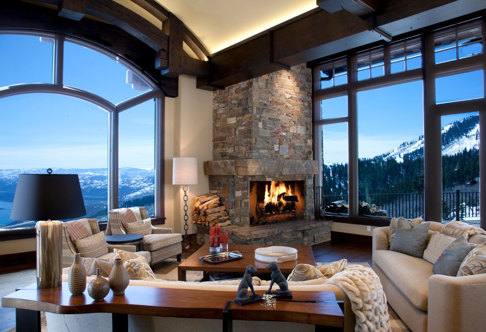 Photo of a country living room in Salt Lake City with beige walls, dark hardwood floors, a standard fireplace and a stone fireplace surround.