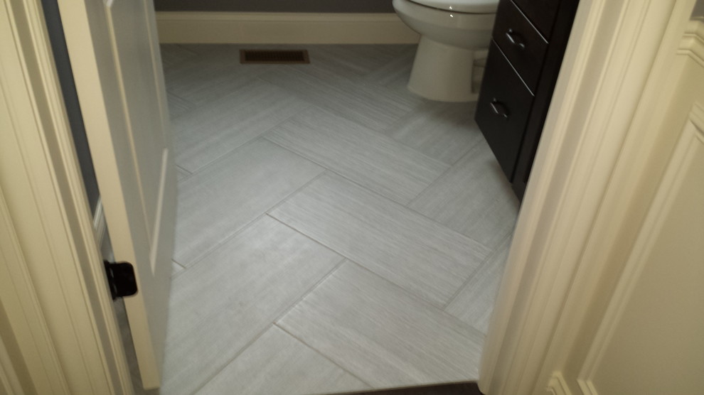 Photo of a small eclectic 3/4 bathroom in Chicago with porcelain floors, flat-panel cabinets, dark wood cabinets, a two-piece toilet, gray tile, porcelain tile, grey walls and grey floor.