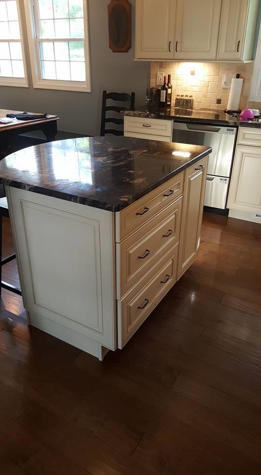Kitchen - mid-sized transitional l-shaped dark wood floor kitchen idea in Baltimore with white cabinets, beige backsplash, stainless steel appliances and an island
