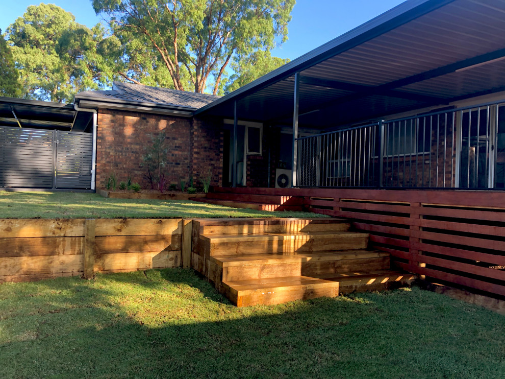 Design ideas for a mid-sized traditional backyard deck in Sydney with a pergola.
