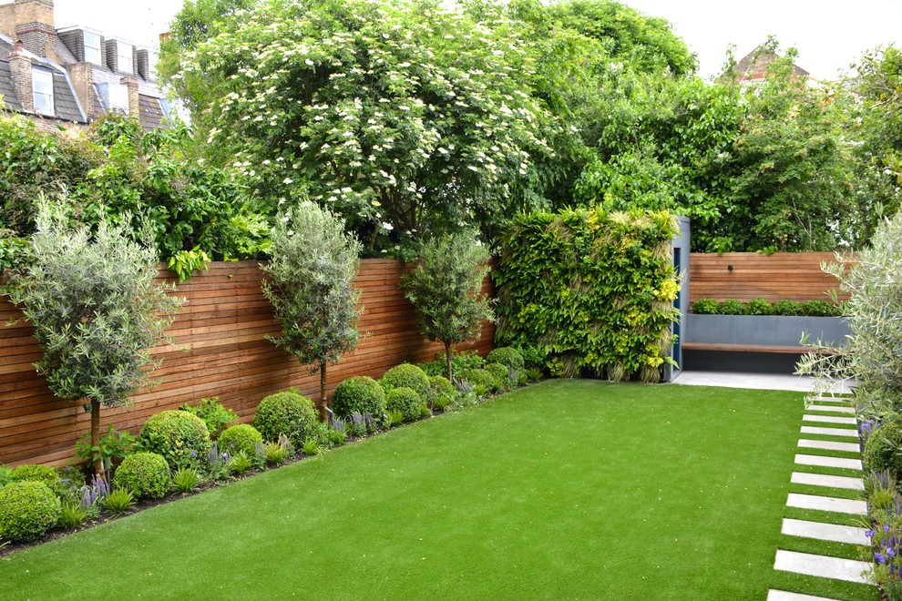 Design ideas for a mid-sized contemporary backyard full sun garden in London with natural stone pavers.