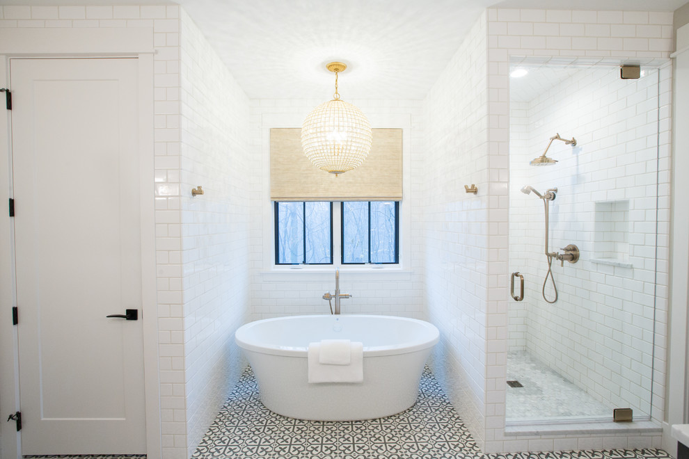 Mid-sized modern master bathroom in Other with shaker cabinets, grey cabinets, a freestanding tub, an alcove shower, a two-piece toilet, white tile, subway tile, white walls, cement tiles, an undermount sink, marble benchtops, grey floor, a hinged shower door and white benchtops.