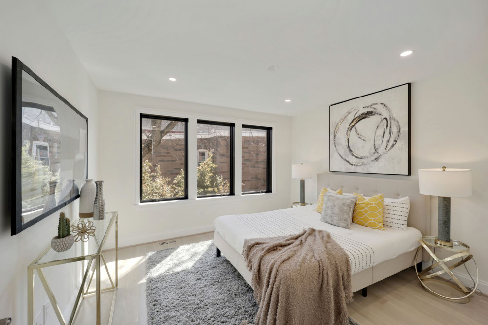 Contemporary guest bedroom in DC Metro with light hardwood floors and brown floor.