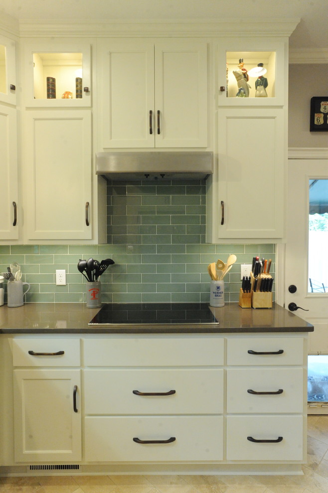 Home design - transitional u-shaped travertine floor home design idea in Atlanta with a single-bowl sink, recessed-panel cabinets, white cabinets, quartz countertops, green backsplash, glass tile backsplash, stainless steel appliances and an island