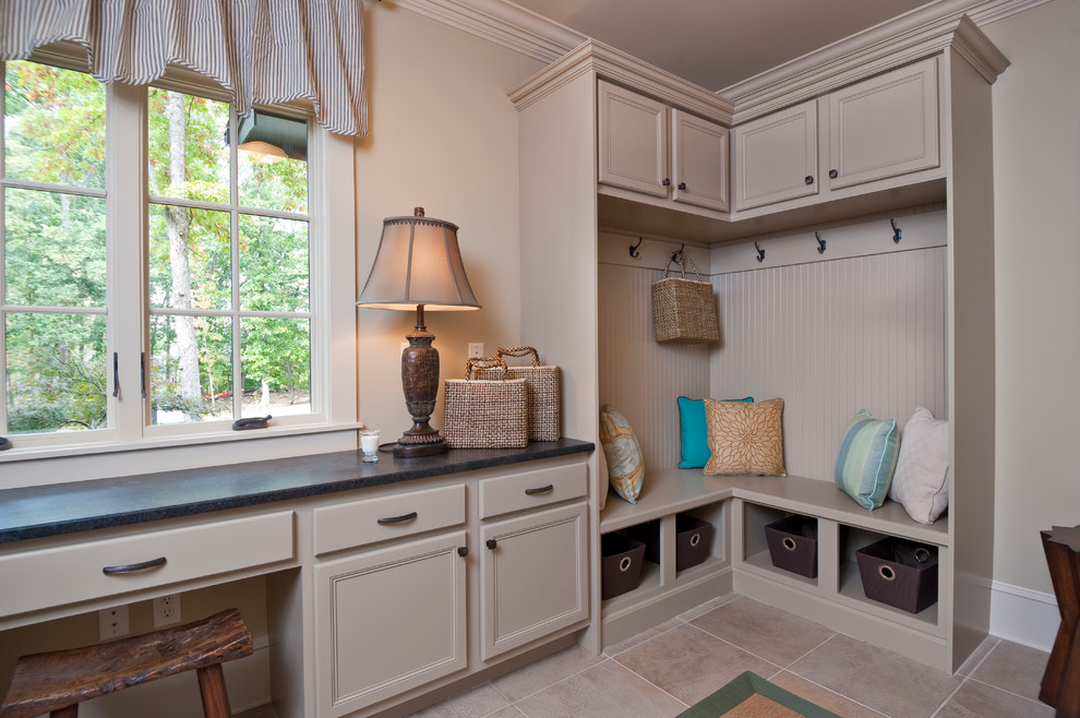 Photo of a traditional laundry room in Other with beige cabinets and beige floor.