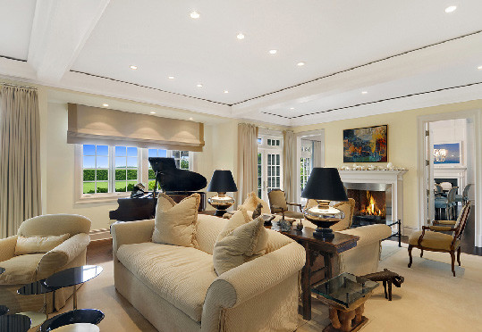Photo of a large contemporary formal enclosed living room in New York with beige walls, carpet, a standard fireplace and a wood fireplace surround.