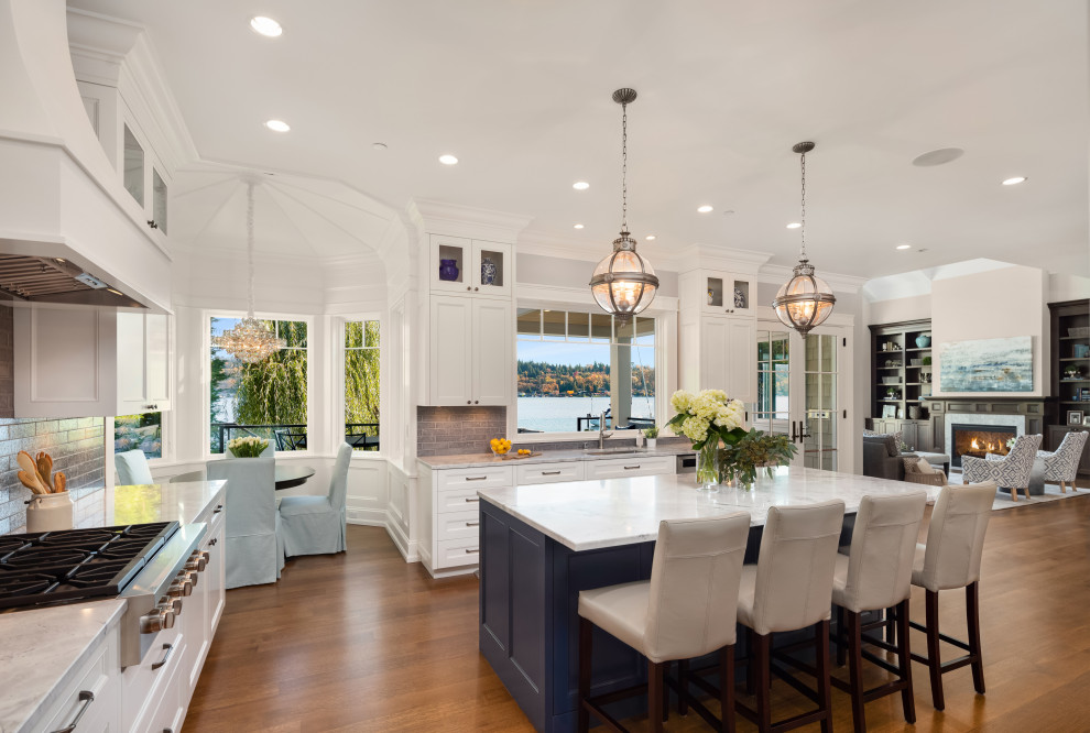 Kitchen - transitional l-shaped dark wood floor and brown floor kitchen idea in Seattle with an undermount sink, recessed-panel cabinets, white cabinets, gray backsplash, stainless steel appliances, an island and white countertops