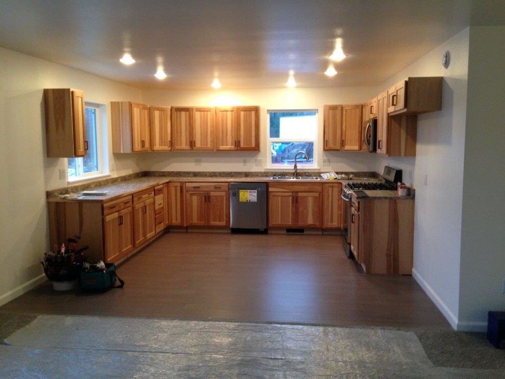 Photo of a mid-sized traditional u-shaped eat-in kitchen in Other with a double-bowl sink, recessed-panel cabinets, light wood cabinets, granite benchtops, stainless steel appliances, dark hardwood floors and no island.