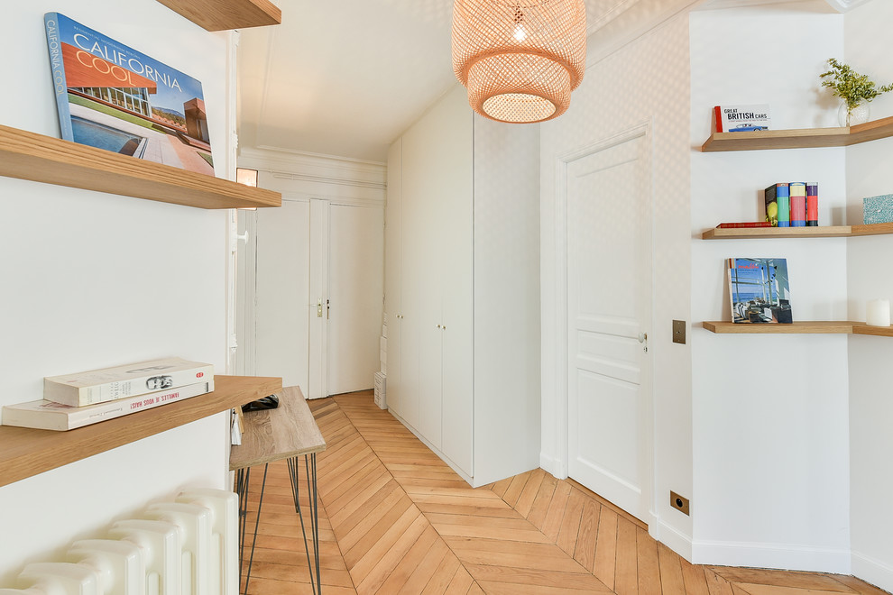 Large contemporary vestibule in Paris with white walls, light hardwood floors, a double front door and a white front door.
