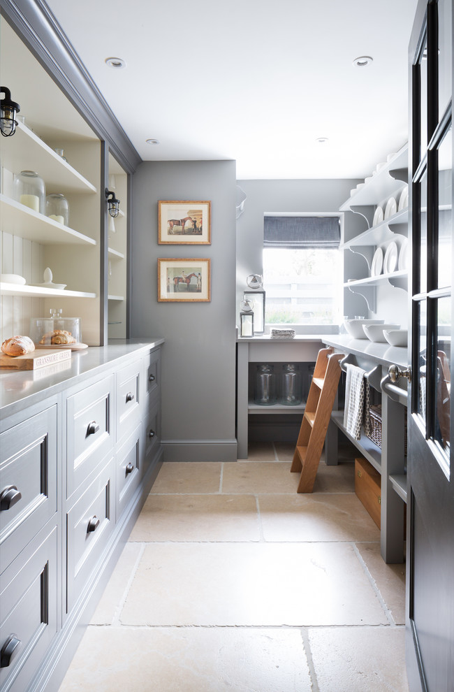 Design ideas for a mid-sized traditional galley kitchen pantry in Essex with shaker cabinets, grey cabinets, stainless steel benchtops, travertine floors and beige floor.