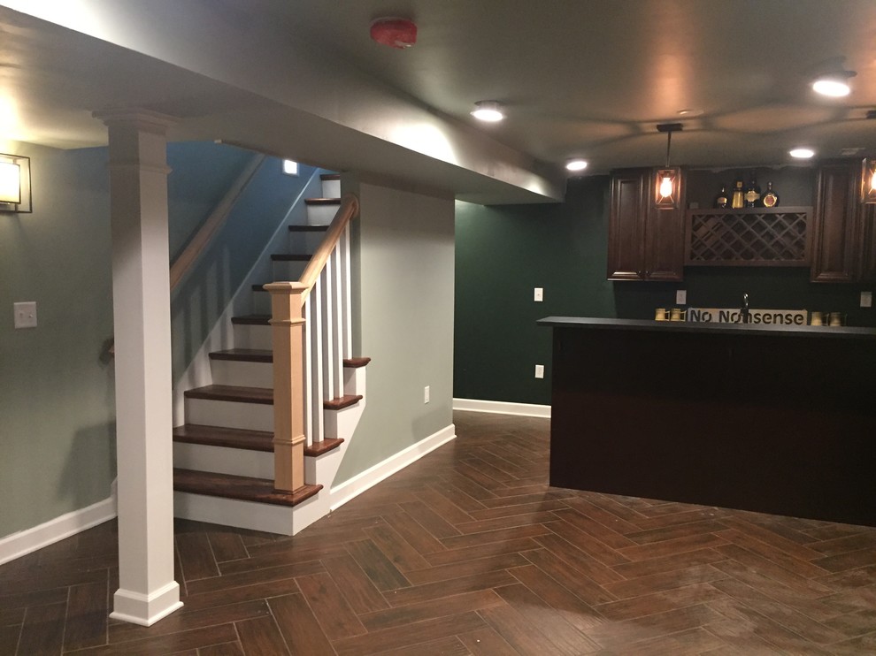 Photo of a mid-sized country fully buried basement in Indianapolis with green walls, porcelain floors and brown floor.