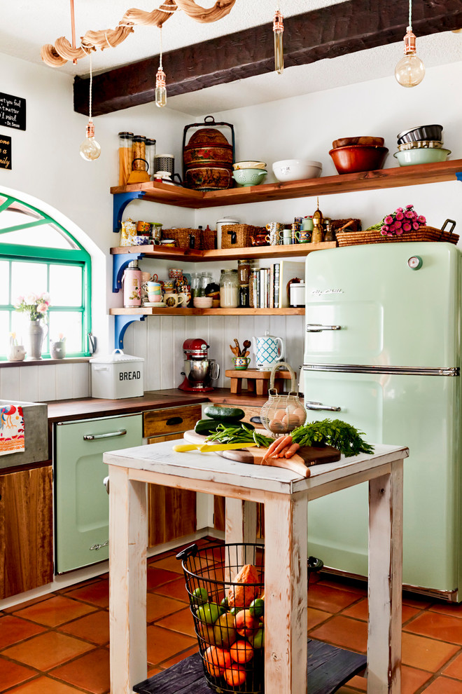 Small country l-shaped kitchen in Miami with a farmhouse sink, open cabinets, medium wood cabinets, wood benchtops, white splashback, coloured appliances, terra-cotta floors, with island and orange floor.