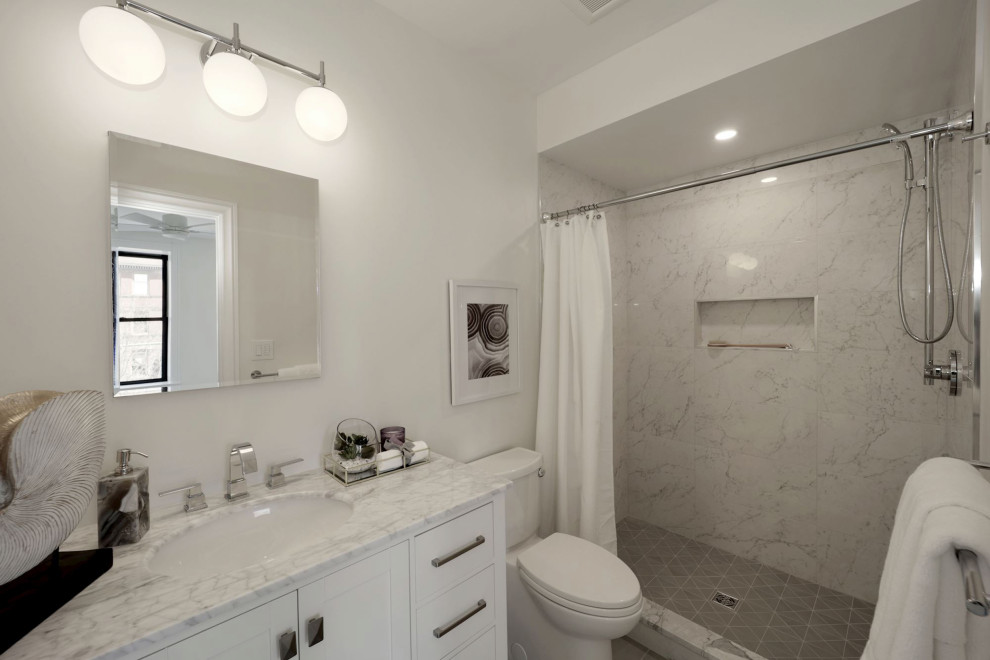 Inspiration for a contemporary 3/4 bathroom in DC Metro with a shower/bathtub combo, a one-piece toilet, white tile, white walls, an undermount sink, a shower curtain, white benchtops, a single vanity, shaker cabinets, white cabinets and a niche.