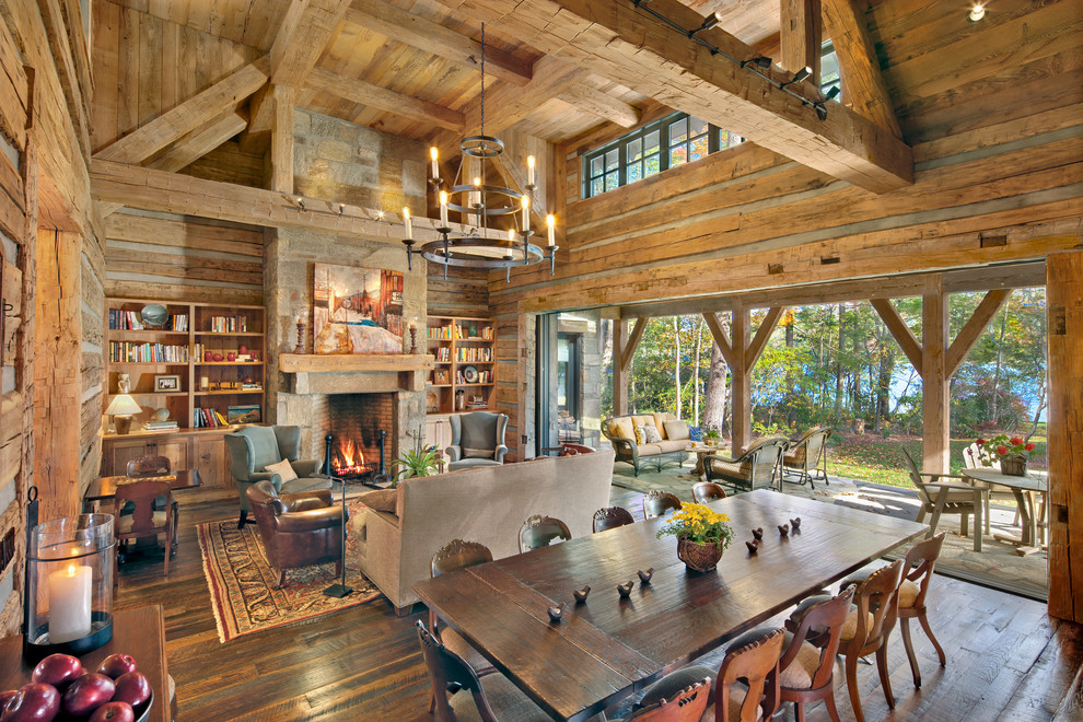 Large country open plan dining in Other with brown walls, medium hardwood floors, a standard fireplace and a stone fireplace surround.