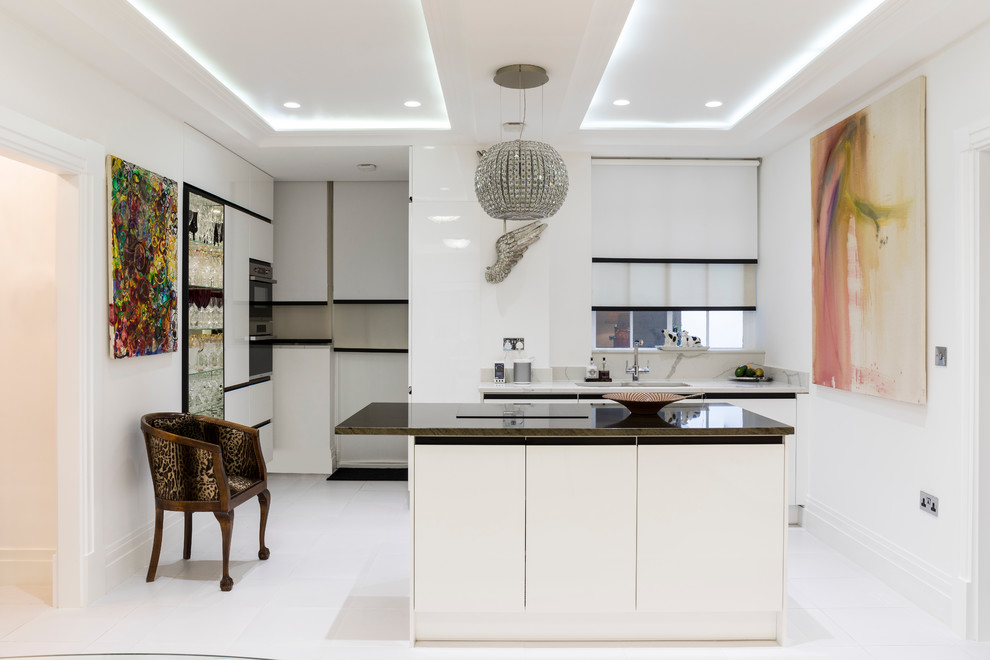 Design ideas for a mid-sized contemporary l-shaped open plan kitchen in London with a drop-in sink, flat-panel cabinets, white cabinets, marble benchtops, grey splashback, stone slab splashback, panelled appliances, with island, white floor, porcelain floors and brown benchtop.