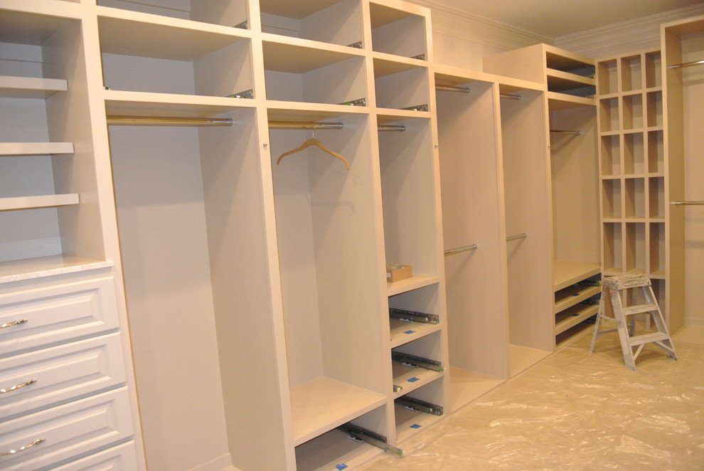 Large transitional gender-neutral carpeted walk-in closet photo in Dallas with raised-panel cabinets and beige cabinets