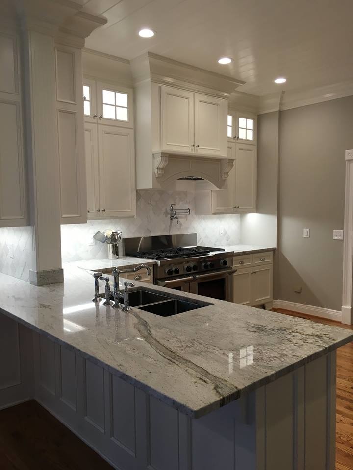 Photo of a contemporary l-shaped separate kitchen in Nashville with a double-bowl sink, recessed-panel cabinets, white cabinets, white splashback, stainless steel appliances, medium hardwood floors and a peninsula.