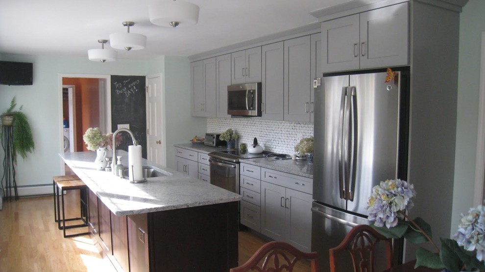 Transitional single-wall light wood floor eat-in kitchen photo in Orange County with a single-bowl sink, shaker cabinets, gray cabinets, quartzite countertops, multicolored backsplash, ceramic backsplash, stainless steel appliances and an island