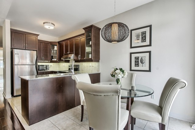 Example of a mid-sized transitional u-shaped eat-in kitchen design in Toronto with a double-bowl sink, recessed-panel cabinets, medium tone wood cabinets, stainless steel appliances and a peninsula