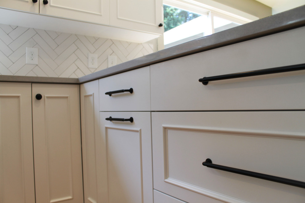 Inspiration for a mid-sized transitional u-shaped medium tone wood floor eat-in kitchen remodel in Seattle with an undermount sink, shaker cabinets, white cabinets, quartz countertops, white backsplash, ceramic backsplash, stainless steel appliances, a peninsula and gray countertops