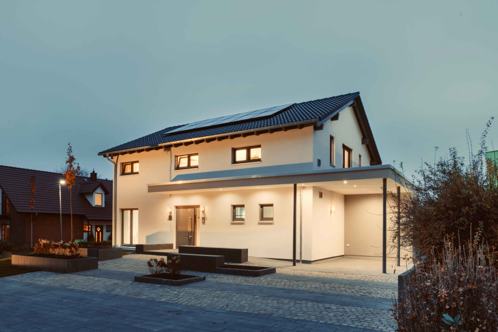 Ejemplo de fachada de casa blanca y gris moderna de tamaño medio de dos plantas con revestimiento de estuco, tejado a dos aguas y tejado de teja de barro