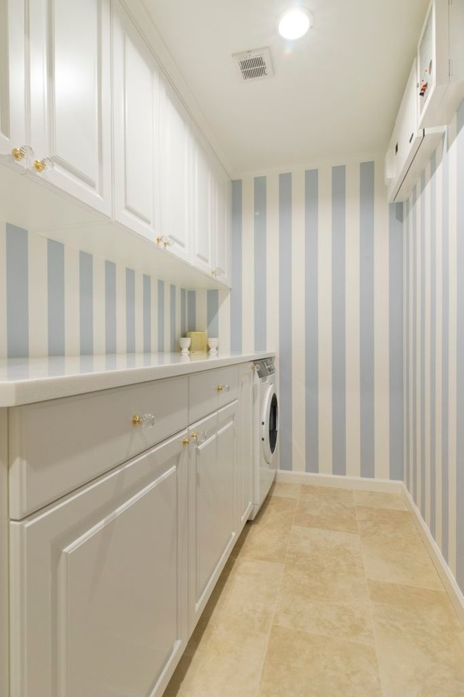 This is an example of a mid-sized traditional single-wall laundry cupboard in Tokyo Suburbs with raised-panel cabinets, white cabinets, blue walls, ceramic floors and an integrated washer and dryer.