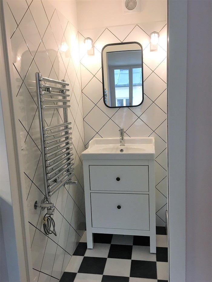 Inspiration for a small traditional 3/4 bathroom in Paris with white tile, porcelain tile, white walls, ceramic floors, a console sink, a sliding shower screen, white benchtops, white cabinets, a double shower and black floor.