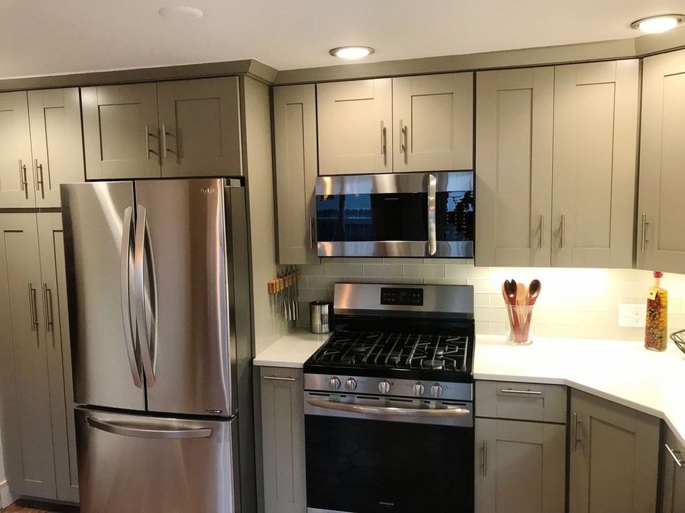 Small transitional l-shaped eat-in kitchen in Denver with an undermount sink, shaker cabinets, green cabinets, granite benchtops, white splashback, glass tile splashback, stainless steel appliances, no island, porcelain floors and red floor.