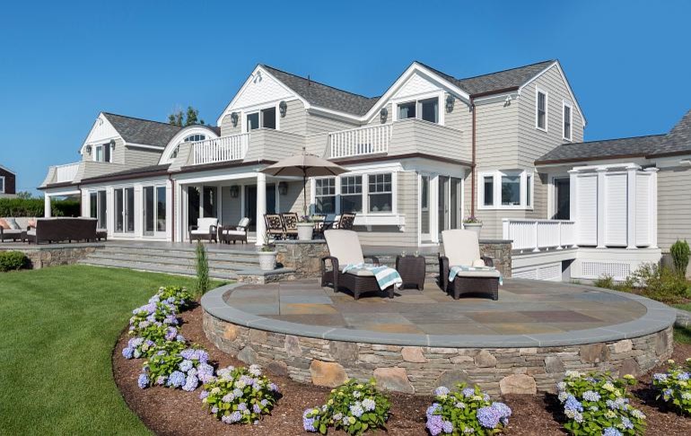 Large traditional backyard patio in Providence with natural stone pavers.