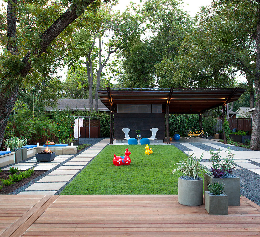 This is an example of a contemporary partial sun garden in Austin with a fire feature and concrete pavers.