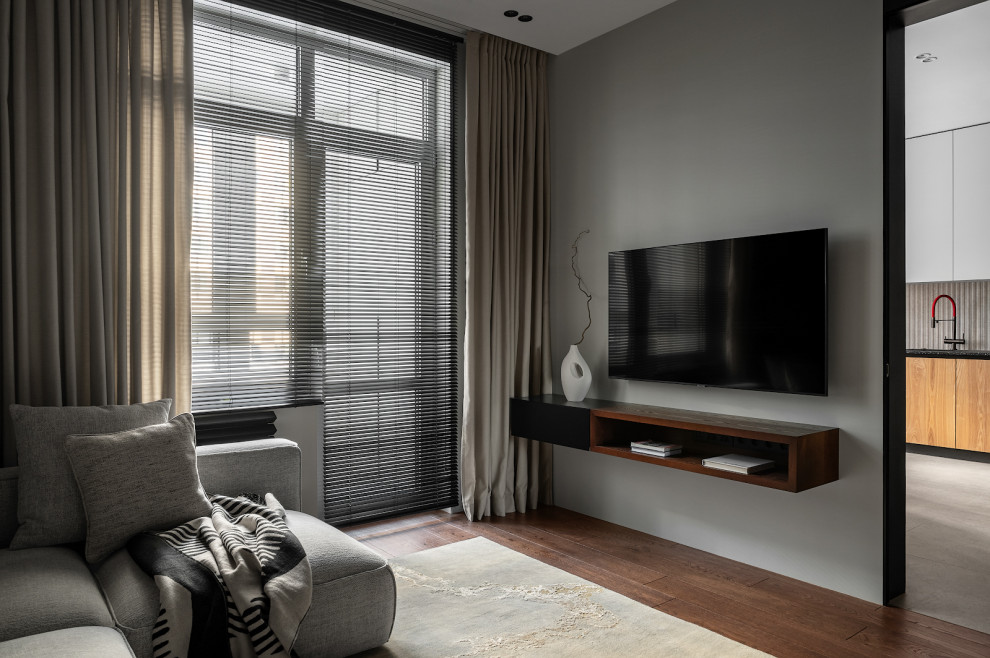 На фото: серо-белая гостиная комната среднего размера в современном стиле с черными стенами, паркетным полом среднего тона, телевизором на стене, зоной отдыха и ковром на полу