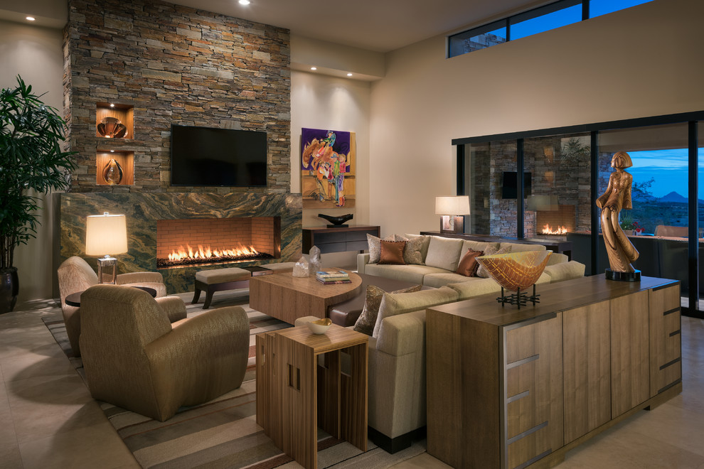 This is an example of a large contemporary open concept living room in Phoenix with beige walls, travertine floors, a standard fireplace, a stone fireplace surround and a wall-mounted tv.